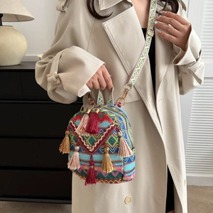 Ethnic bohemian mini backpack with colorful tassels and woven strap on a model