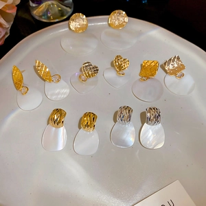 Vista dettagliata di orecchini a cuore e foglia placcati oro 24k con perle di conchiglia