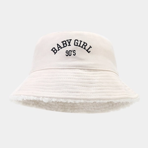 Detail of embroidered BABY GIRL 90'S text on cream suede bucket hat with faux fur lining
