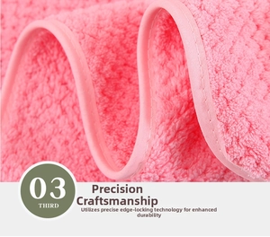 Detailed macro shot of pink coral fleece towel with reinforced overlock edge stitching