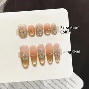 Pink gold gradient press-on nails with blue relief flowers, pearls, and crystals