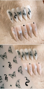 Détail de stickers ongles mats avec motifs noirs de papillons, serpents et étoiles