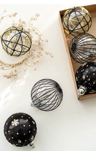 Close-up of black and gold Christmas ball ornaments with intricate textures and elegant patterns