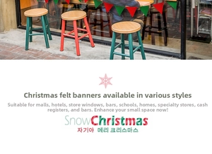 Detail of red and green felt Christmas bunting banners hanging in a shop window display