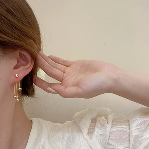 Elegant gold-plated metal ball tassel earrings shown being worn for a stylish look
