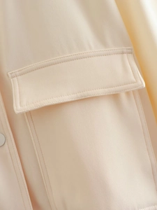 Detailed close-up of apricot twill fabric with flap pocket and double stitching