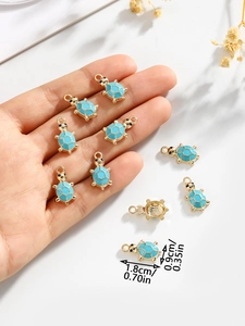 Detail view of a light blue turtle charm with dimensions on a white background