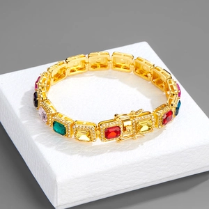 Close-up of golden Cuban link chain with square multi-color gems and crystal pave detail