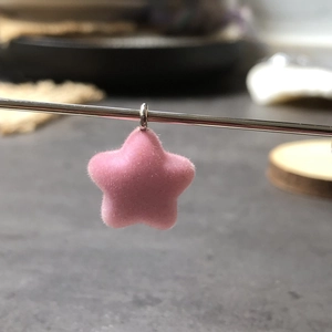 Detailed macro shot of soft pink flocked star pendant with silver metallic ring