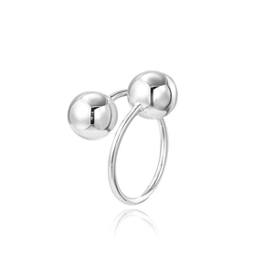 Detailed close-up of a silver bypass ring featuring two polished spheres on a white background