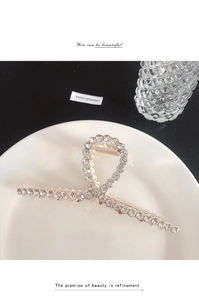 Gros plan d'une pince à cheveux dorée avec strass sur une assiette en céramique