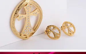 Detail of gold titanium cross jewelry set featuring sparkling inlaid zircons and vintage patterns