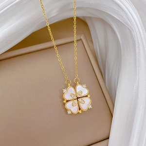 Vue macro d'un collier trèfle doré avec nacre blanche et détails en cristal brillant