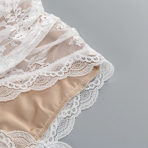 Gros plan sur la dentelle blanche élégante avec doublure beige et maille détaillée
