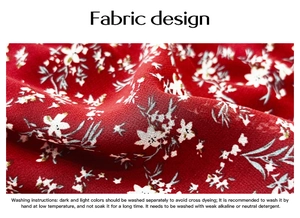 Detail view of red floral fabric texture with white patterns and washing instructions