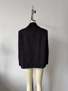 Detailed back view of a black pinstripe blazer with classic French commuting style design