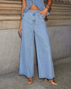 Détail d'un jean large bleu clair avec boutons dorés vintage à la taille élastique