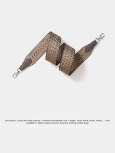 Detail of grey chevron woven bag strap with silver metal hooks and cowhide leather ends