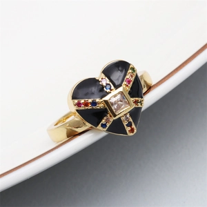 Detailed close-up of heart-shaped ring with black enamel and multicolored crystals