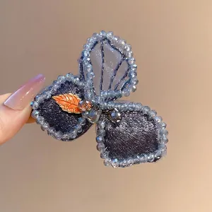 Blue beaded butterfly hair clip with crystal embroidery and orange leaf accent