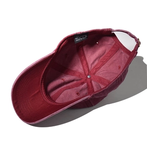 Detailed interior of washed burgundy cotton baseball cap with adjustable metal buckle