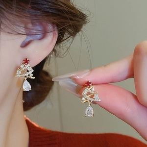 Close-up of Christmas tree stud earrings with zircon and pearls on woman's ear