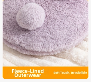 Close-up of soft purple faux rabbit fur plush cover with fluffy pom-poms for hot water bag