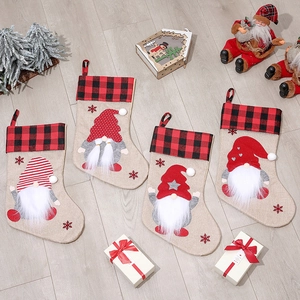 Set of 4 gnome Christmas stockings with buffalo plaid cuffs on a wooden background