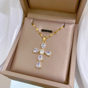 Detail of cross pendant necklace featuring five pear-shaped cubic zirconia and gold chain