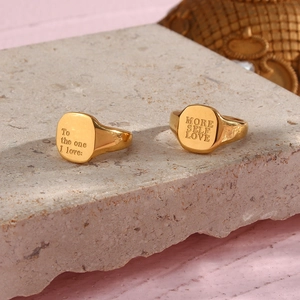 Detail of 18K gold plated steel rings with engraved motivational quotes on stone