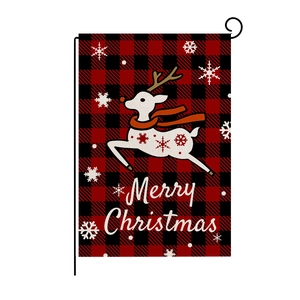 Close-up of a Merry Christmas garden flag with a white reindeer on red plaid linen