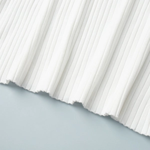 Detail shot of white ribbed knit dress fabric with high density wavy hemline edge