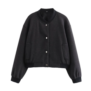 Détail d'une veste en tweed noire avec boutons-pression en argent et bords côtelés