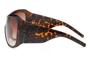 Detail of oversized tortoiseshell sunglasses featuring embossed geometric lattice temples