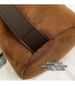 Macro shot of brown suede bucket bag featuring reinforced leather base with neat stitching