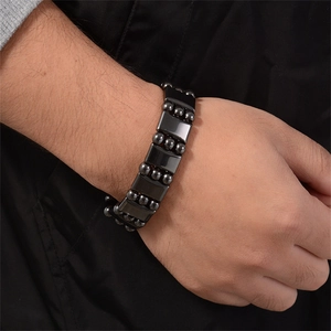 Close-up of black magnetic hematite bracelet with rectangular and round beads on wrist