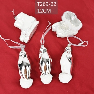 Detail view of 12cm silver penguin and ice skates Christmas ornaments on red fabric