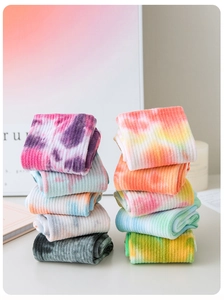 Detailed view of ten pairs of colorful tie-dye cotton pilates socks neatly stacked on a desk
