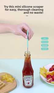 Detail of mini silicone spatula reaching into a slim jar to extract cosmetic residue
