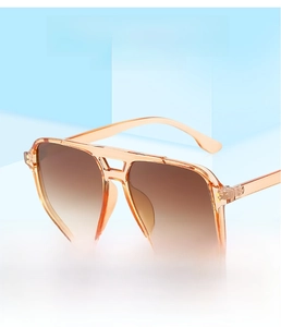 Detail of pilot sunglasses with orange frames and brown gradient lenses on blue background