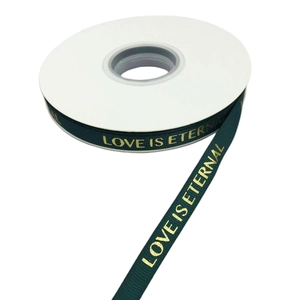 Detail of dark green ribbon with gold LOVE IS ETERNAL lettering for gift wrapping