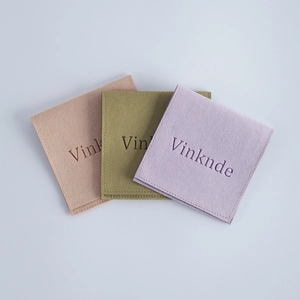 Microfiber velvet jewelry pouches in beige, olive, and purple with minimalist logo