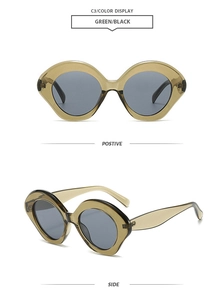 Detail view showing green oval frame sunglasses with grey lenses and thick resin texture
