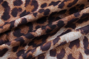 Detailed close-up of brown leopard print mesh fabric with soft knit texture