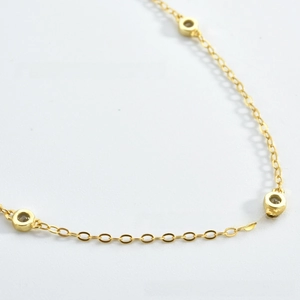 Macro shot of gold-plated O-chain necklace with bezel-set round cubic zirconia details