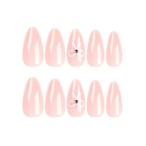 Pink almond press on nails featuring white bow designs and rhinestones on white background