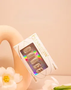 Close-up of nude cat-eye press-on nails with 3D crystal accents in white premium box