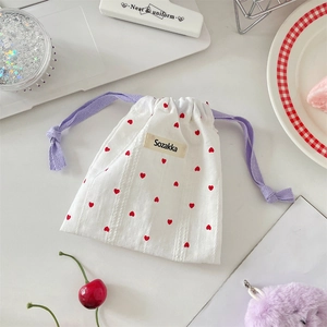 Detail of white cotton drawstring pouch with red heart print and lavender woven cord
