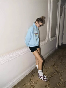 Light blue half-zip sweatshirt with Y2K letter print in a stylish lifestyle setting