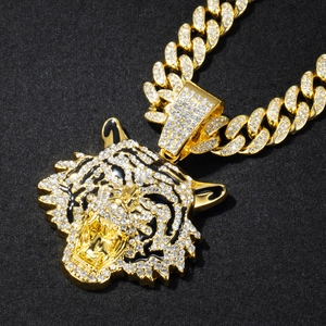 Macro shot of gold cuban chain with luxury iced-out tiger head pendant set with crystals